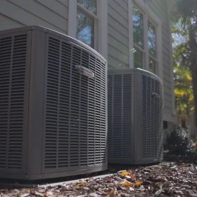 Newly installed heat pump condenser units beside an Aurora, IL home
