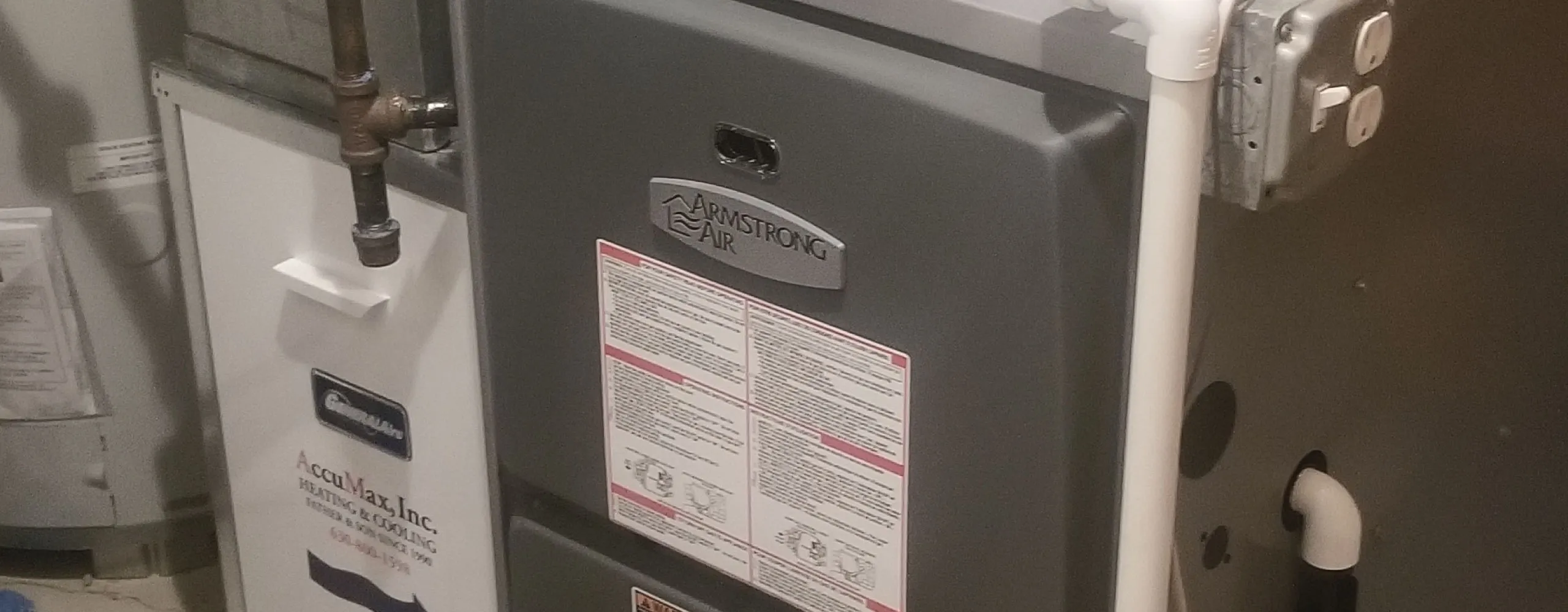 AccuMax technicians servicing a high-efficiency furnace at an Aurora, IL home